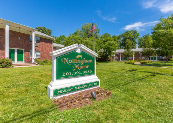 a green and white sign that says northampton manor in front of a brick building