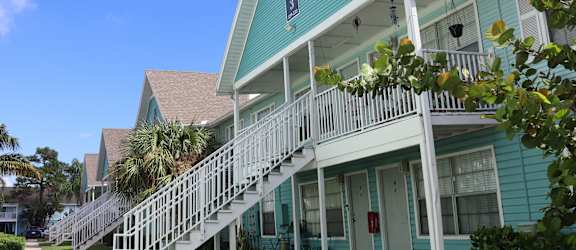 A blue house with a white staircase leading to the front door.
