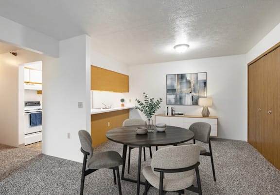 A dining room with a round table and chairs.