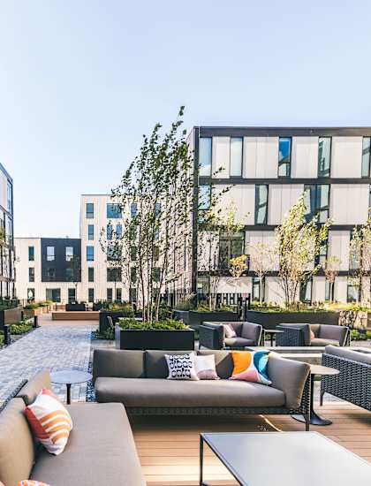 A modern outdoor seating area with couches and tables.