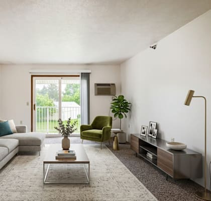 A living room with a grey couch, a green armchair, a coffee table, and a large window.