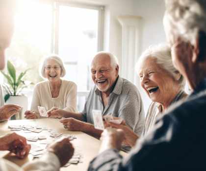 a group of seniors playing a game of cards at a table