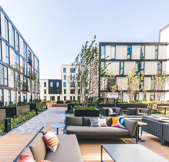 A modern outdoor seating area with couches and tables.