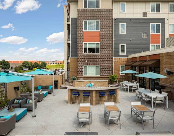 A patio with tables and chairs and umbrellas.