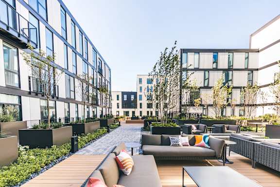 A modern outdoor seating area with couches and tables.