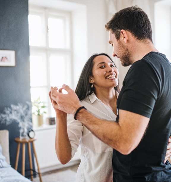 a man and woman dancing in a living room