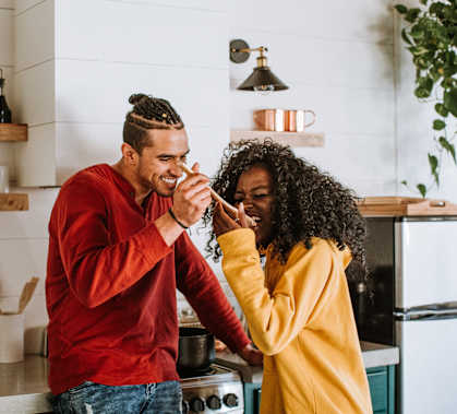 a man and woman standing in a kitchen playing with each other at Ninth Square Apartments, Connecticut, 06510
