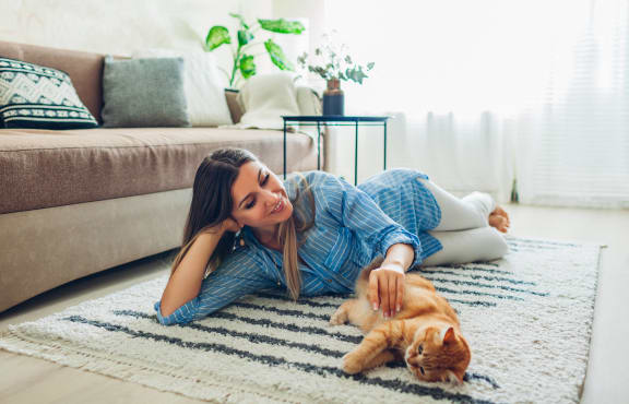 a woman laying on the floor with a cat