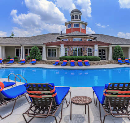 a swimming pool with lounge chairs and a building in the background