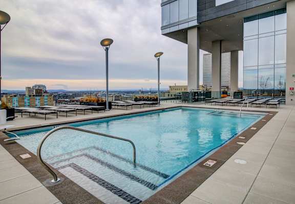 A large indoor swimming pool with a view of the city.