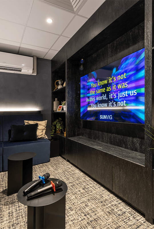 a tv on the wall in a room with a couch and a table