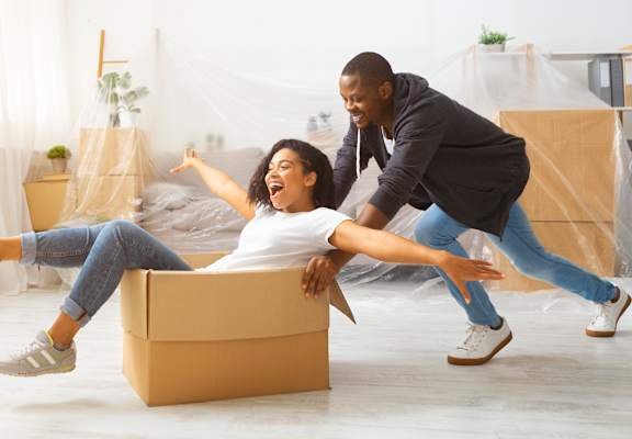 Young couple goofing around with moving boxes