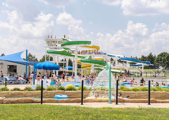A water park with a large water slide and people enjoying the water.