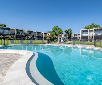 A large outdoor swimming pool with a blue tinted water.