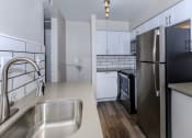 Thumbnail 2 of 22 - an empty kitchen with stainless steel appliances and white cabinets
