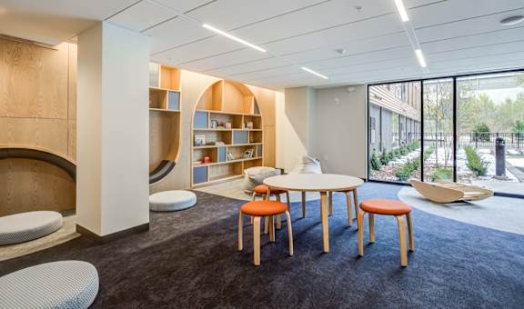 a lounge area with a table and chairs and a window