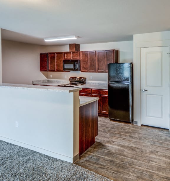 an empty kitchen with a washer and dryer and a refrigerator