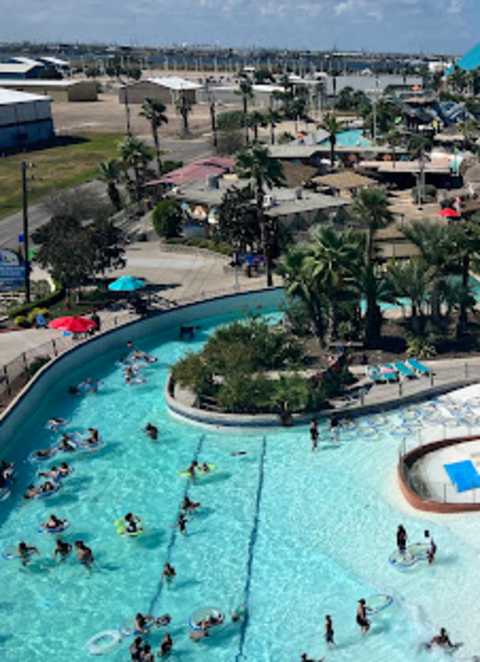 A large water park with people swimming and sliding down water slides.