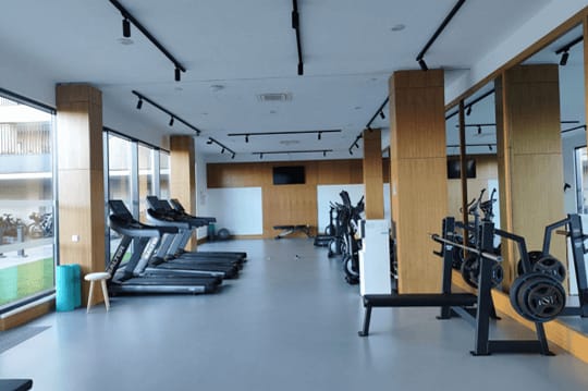 a gym with cardio machines and weights on the floor