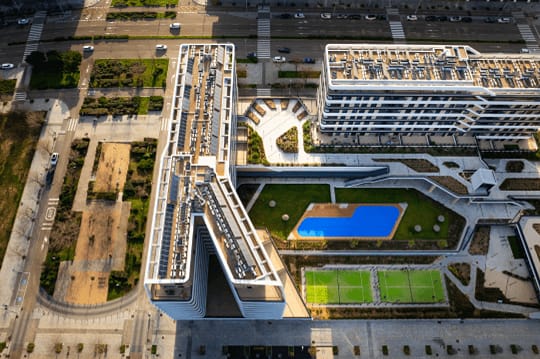 an aerial view of a building with a pedestrian bridge