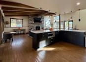 Thumbnail 7 of 27 - A modern kitchen with dark wood floors and a large island.