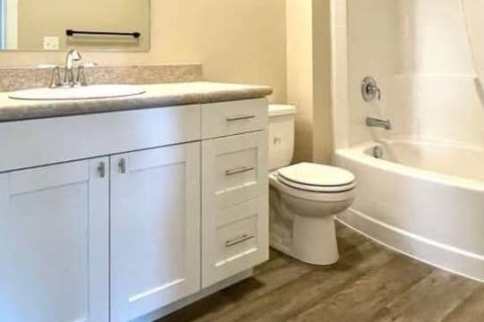 A white bathroom with a toilet, sink, and bathtub.