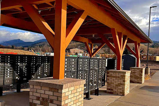 A row of black mailboxes under a red roof.