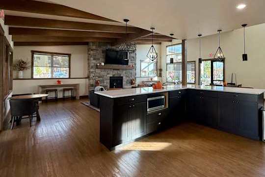 A modern kitchen with dark wood floors and a large island.
