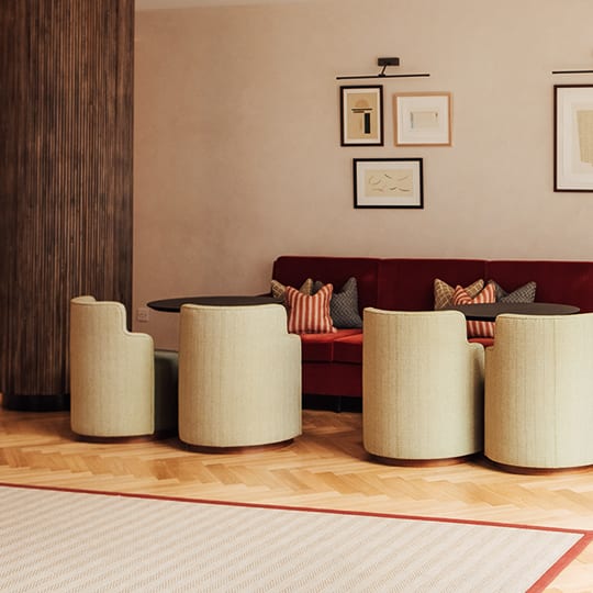 a living room with a red couch and three stools