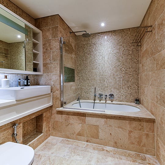 a bathroom with a tub and a sink and a mirror