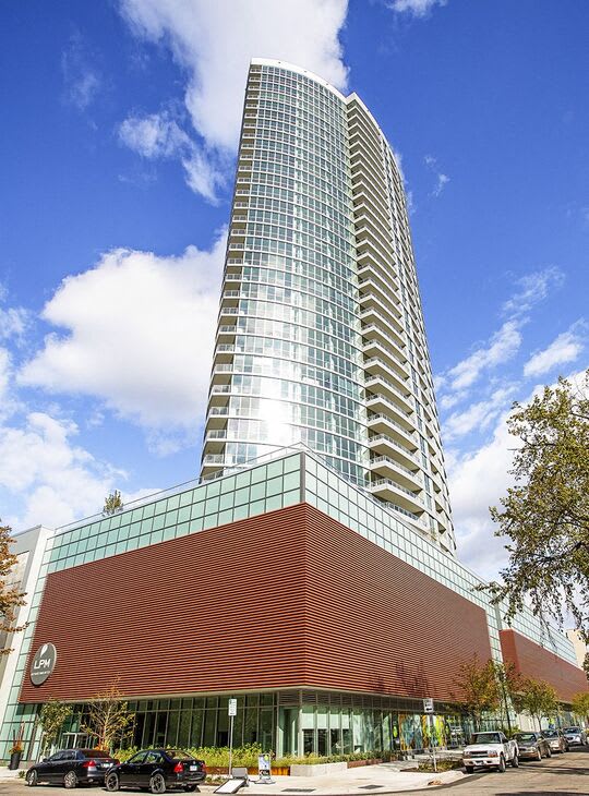 a tall building with cars parked in front of it