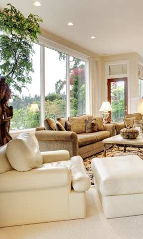 A living room with a large window and a view of trees.