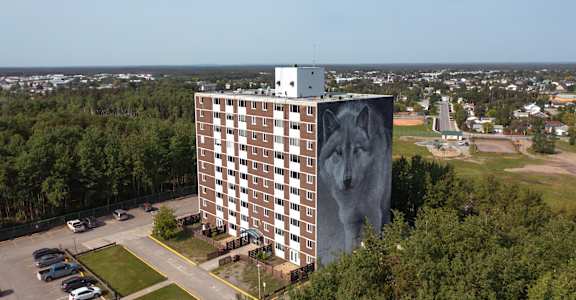 A large building with a mural of a woman's face on the side.