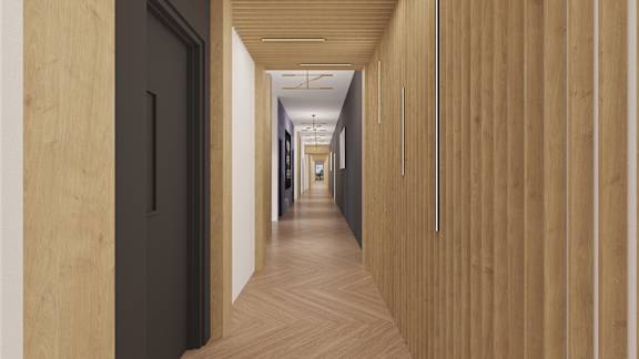 a long hallway with wood floors and black doors