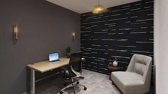 a desk with a laptop and a chair in a room
