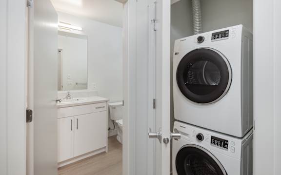 A white washing machine is in a small room.