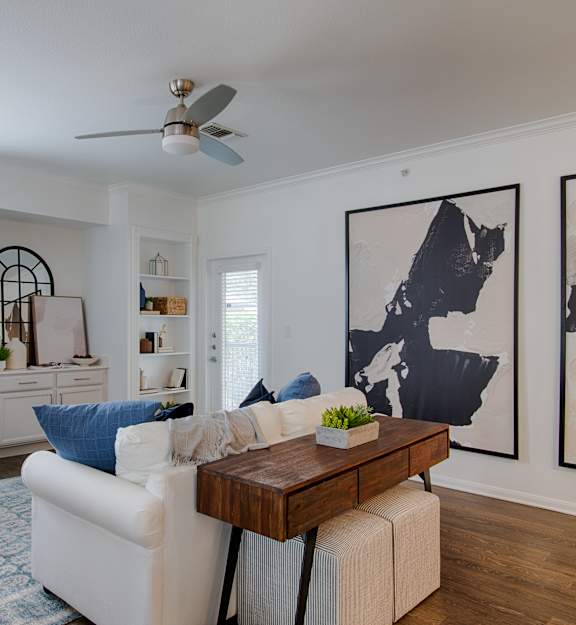 A living room with a white couch and a wooden coffee table.