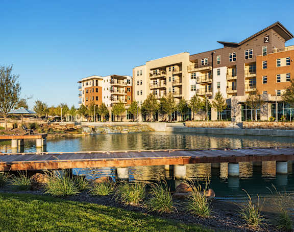 Discovery at the Realm Apartments Building Exterior and Lake with Wooden Pier