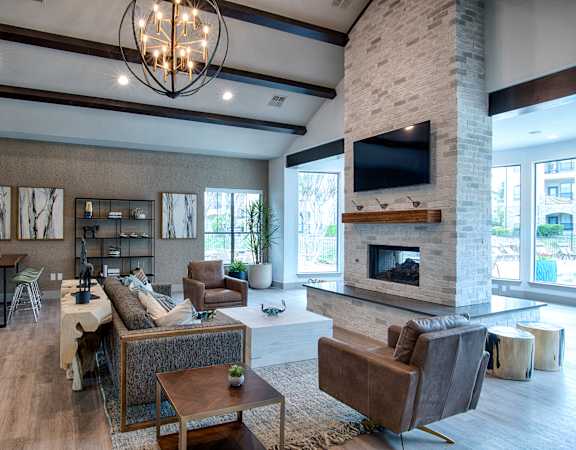 A modern living room with a stone fireplace and a large flat screen TV mounted above it.