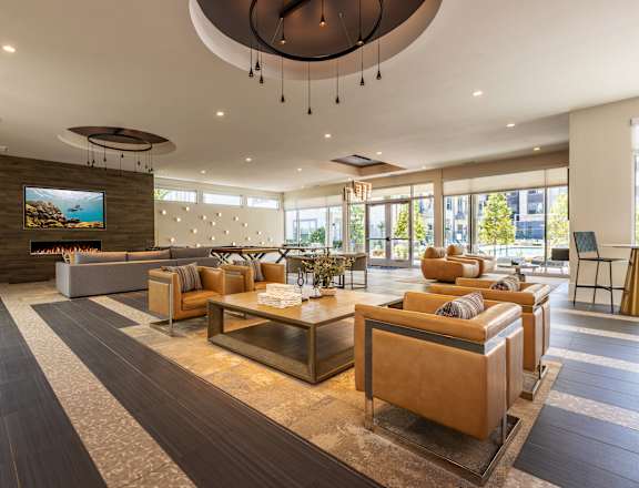 A modern living room with a curved ceiling and a large screen on the wall.