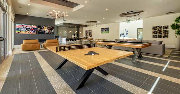 A room with a pool table and a TV on the wall.