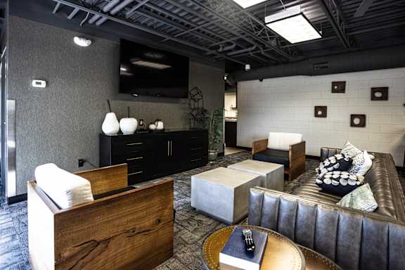 A modern living room with a brown leather couch and a wooden coffee table.