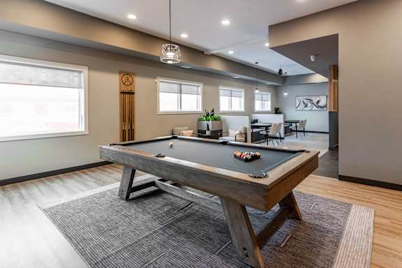 A modern dining room with a long table and chairs.