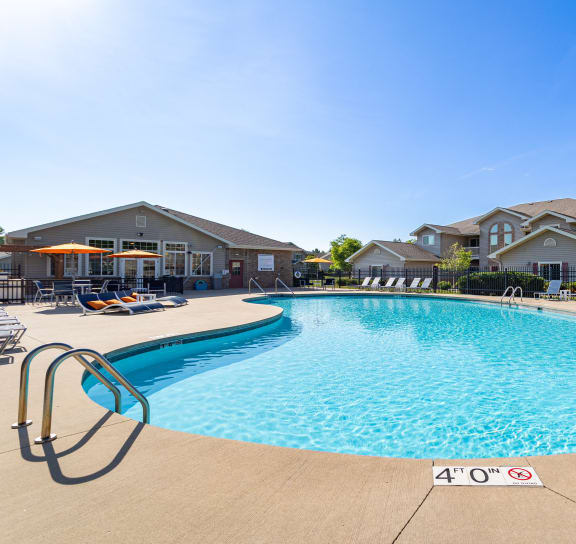 a swimming pool with chaise lounge chairs and trees in the background
