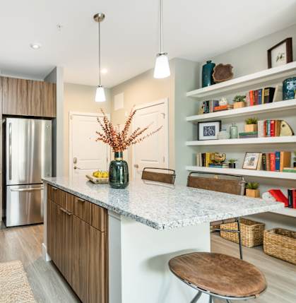 A modern kitchen with wooden cabinets and a granite countertop.