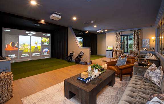 A home theater room with a large screen and comfortable seating.