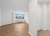 Thumbnail 37 of 59 - A room with wooden floors and white walls.