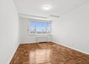 Thumbnail 32 of 59 - A room with a wooden floor and a window with blinds.