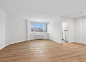 Thumbnail 43 of 59 - A large empty room with wooden floors and white walls.