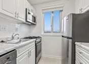 Thumbnail 45 of 59 - A kitchen with white cabinets and appliances.